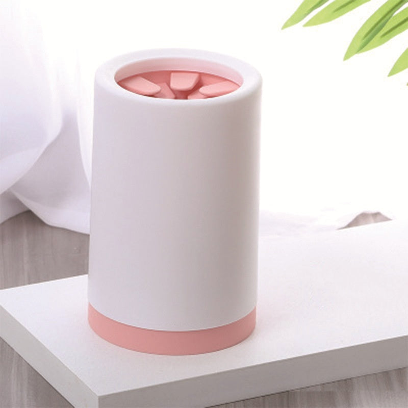 White and pink cylinder paw cleaner with pink interior on a white surface
