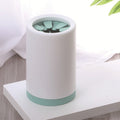 White and green cylindrical paw cleaner on a white surface with a blurred background