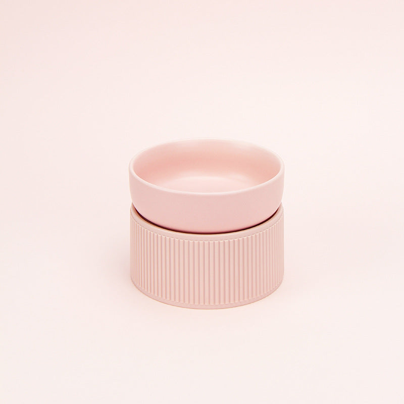 Pink ceramic pet bowl on a light pink background