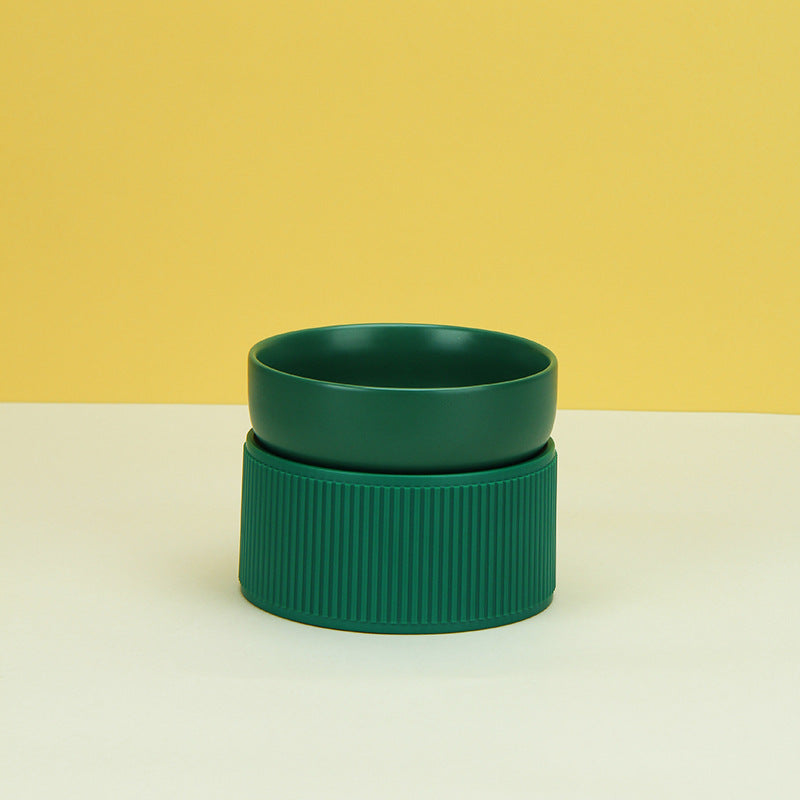 Green ceramic bowl on a white surface with a yellow background